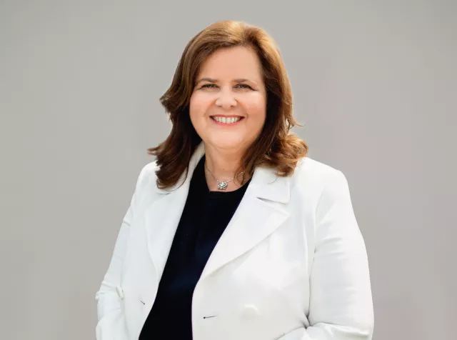 Headshot of Nathalie Bellon, older woman with brown hair in a white blazer looking at the camera smiling