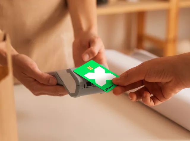 hand tapping green pluxee card on machine to pay at counter